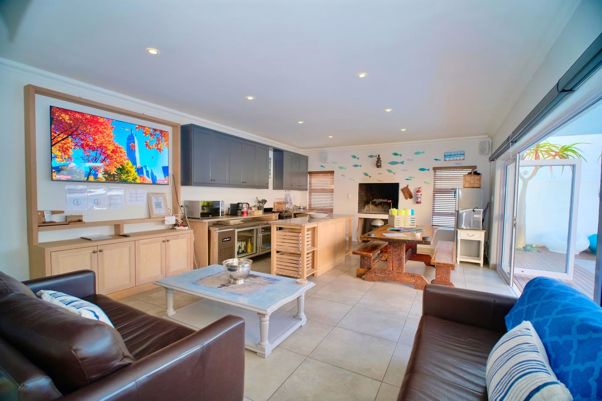 An open-plan living room with a wood-slat ceiling feature and large abstract wall art